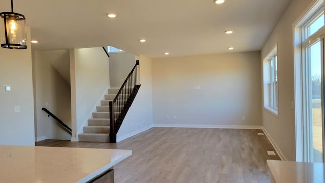 interior space with recessed lighting, wood finished floors, a chandelier, baseboards, and stairs