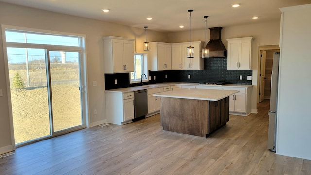 kitchen with custom exhaust hood, light countertops, light wood-style floors, a sink, and black appliances