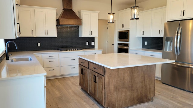 kitchen featuring stainless steel appliances, premium range hood, a sink, and light wood-style flooring