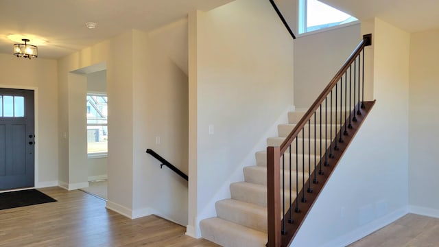 foyer entrance with baseboards and wood finished floors