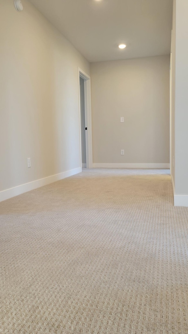 unfurnished room featuring light carpet, baseboards, and recessed lighting