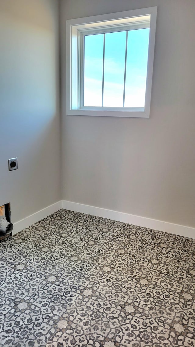 unfurnished room with baseboards