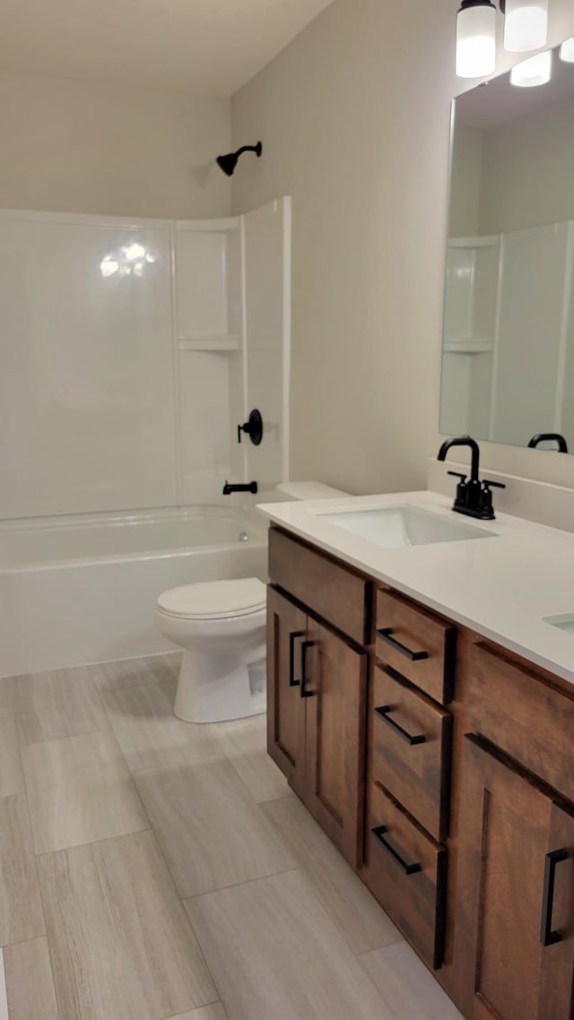 bathroom featuring toilet,  shower combination, and vanity