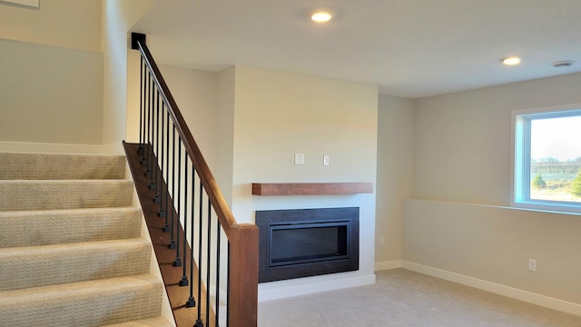 stairs featuring carpet, recessed lighting, a glass covered fireplace, and baseboards