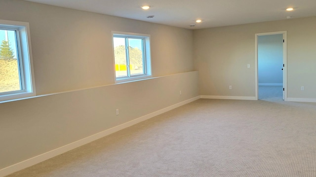 spare room with recessed lighting, light carpet, and baseboards