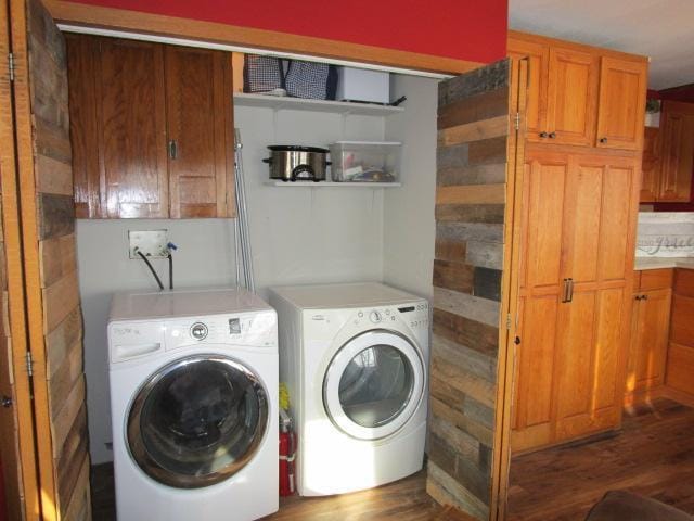 laundry room featuring laundry area, wood finished floors, and washing machine and clothes dryer