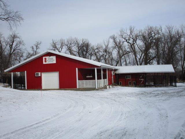 snow covered structure featuring an outbuilding and a pole building