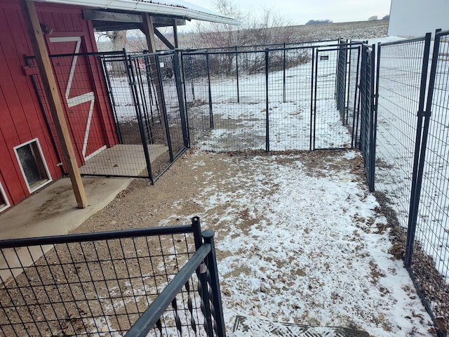 yard covered in snow with an outbuilding and fence