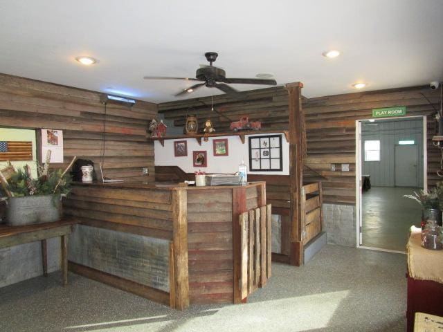 bar featuring ceiling fan, a dry bar, rustic walls, and recessed lighting