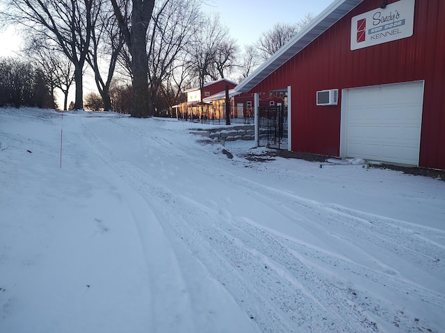 yard covered in snow featuring a garage and an outdoor structure