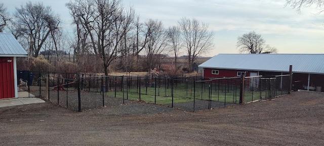 view of yard with an outbuilding, a pole building, and fence