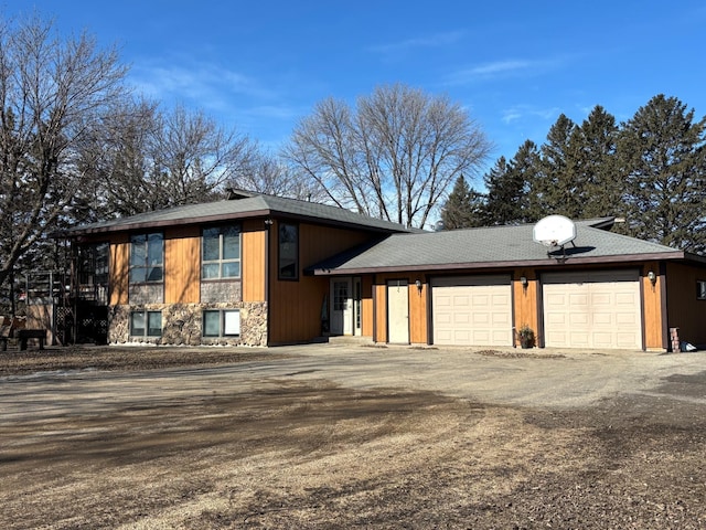 27703 County Road 1, Hancock, MN 56244 - view of front of home with driveway, stone siding, and a garage