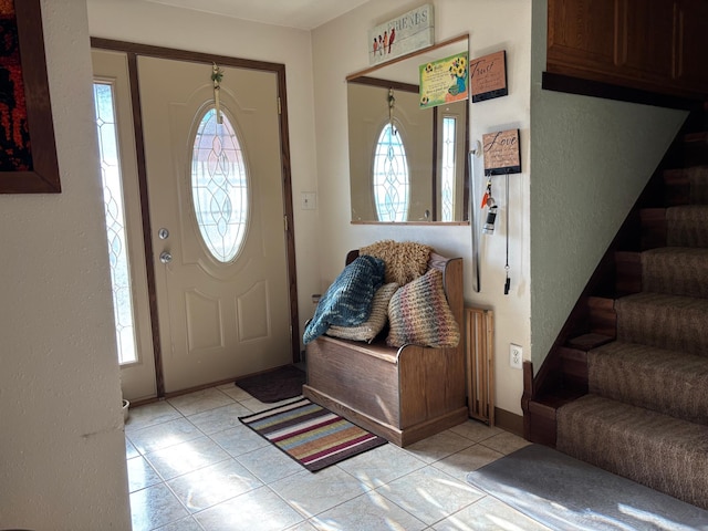 entrance foyer featuring stairway and light tile patterned floors