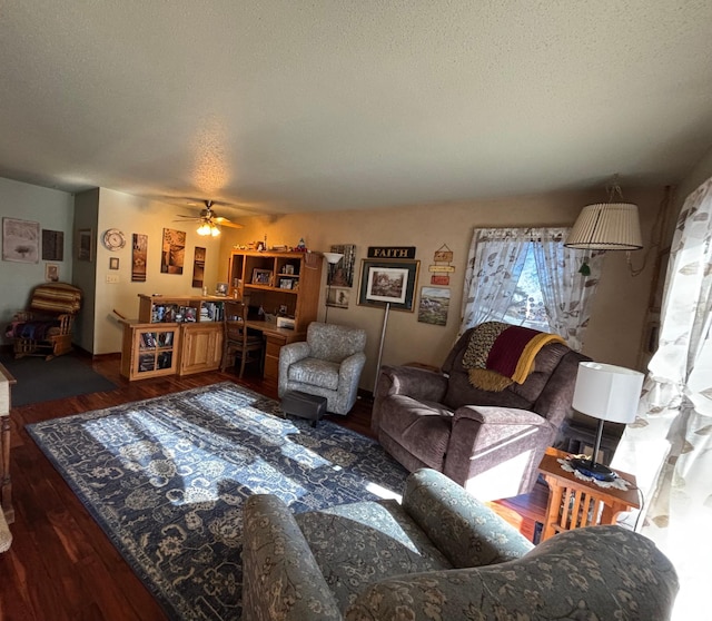 living area with a textured ceiling, wood finished floors, and a ceiling fan