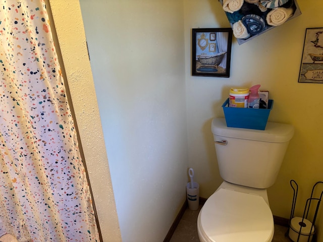 full bath featuring a shower with curtain, baseboards, and toilet