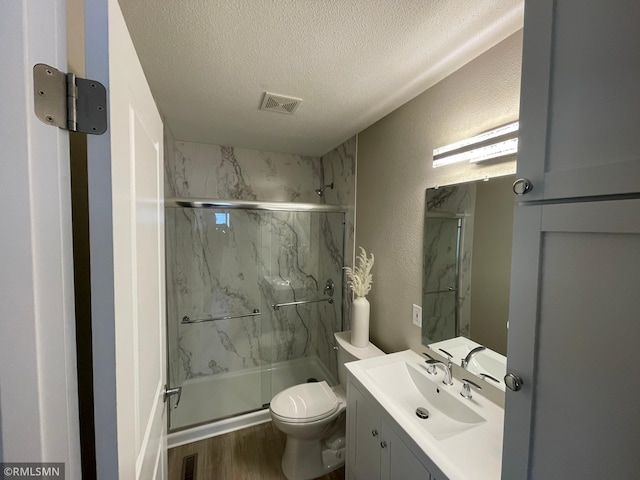 bathroom with visible vents, a textured wall, a textured ceiling, and a marble finish shower