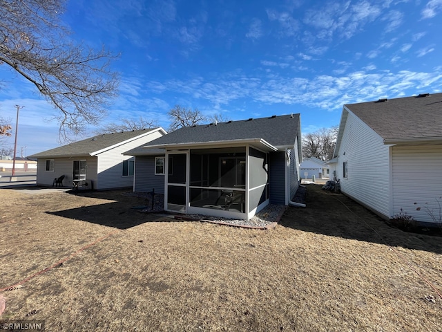 rear view of property featuring a sunroom