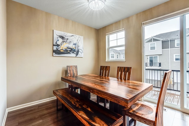 dining area with baseboards and wood finished floors