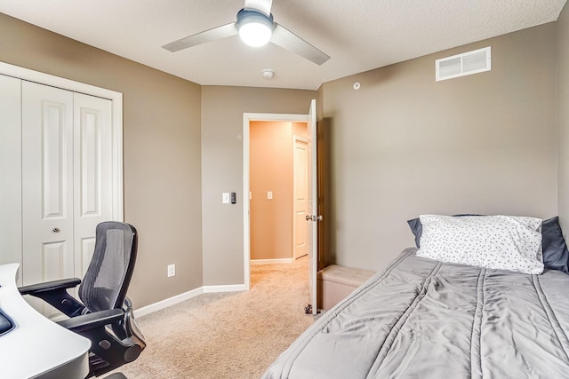 carpeted bedroom featuring a closet, visible vents, ceiling fan, and baseboards