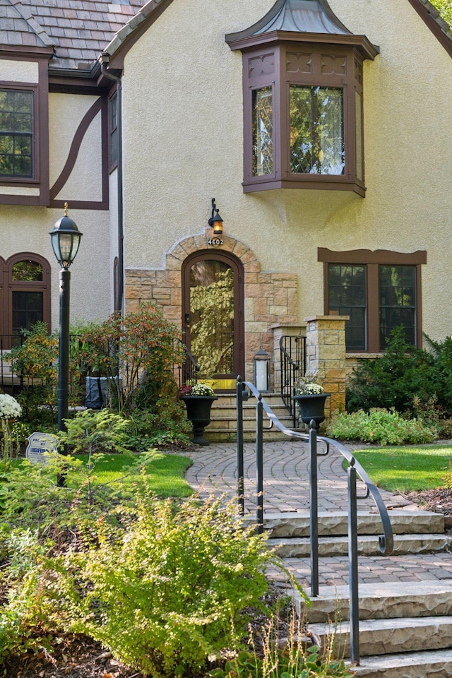 view of front of home featuring stone siding and stucco siding