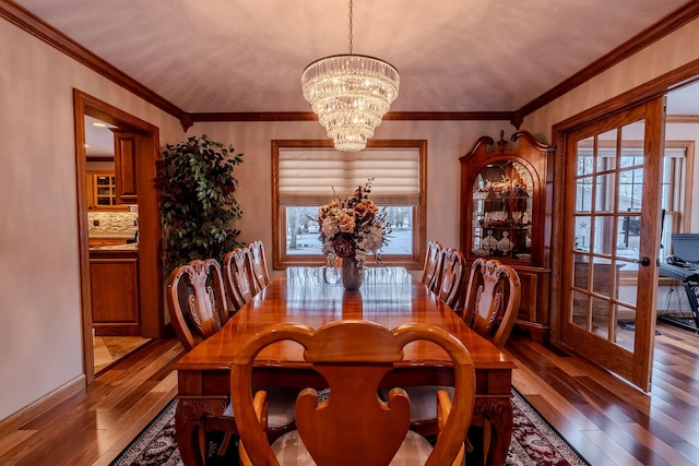 dining space featuring an inviting chandelier, wood-type flooring, and ornamental molding