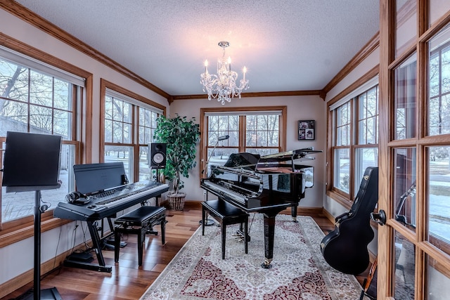 sitting room featuring a textured ceiling, a notable chandelier, wood finished floors, baseboards, and ornamental molding