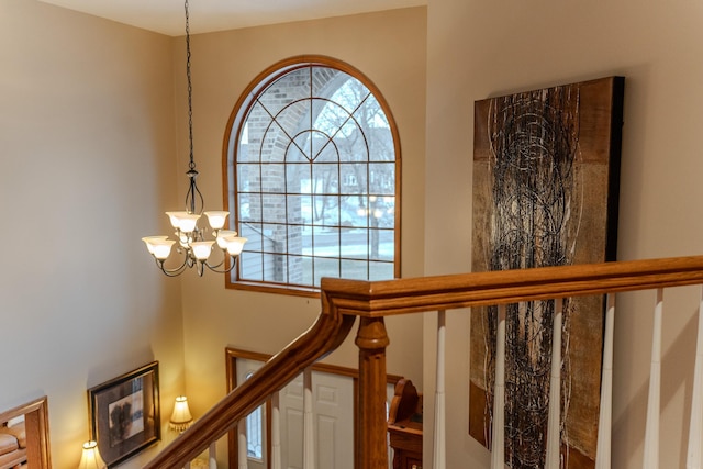 stairway featuring a chandelier