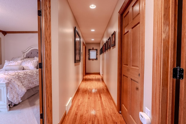 hallway with recessed lighting, light wood-type flooring, and baseboards