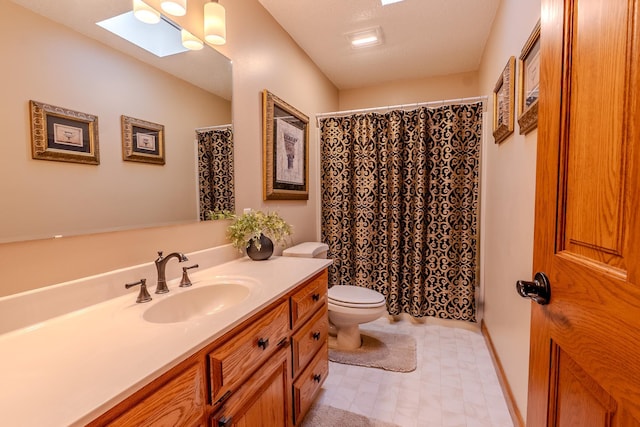 bathroom featuring a skylight, a shower with shower curtain, toilet, vanity, and tile patterned floors