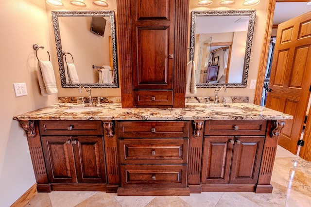 bathroom with a sink, baseboards, and double vanity