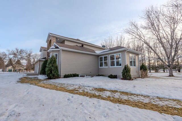 view of snow covered exterior featuring an attached garage