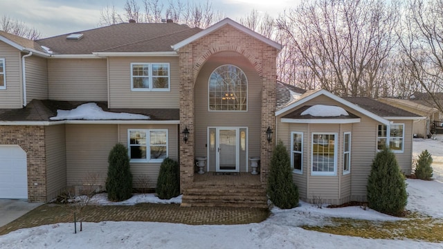 view of front of house with a garage, a shingled roof, and brick siding