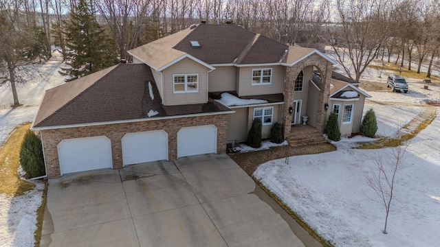 view of front of home featuring a garage, concrete driveway, brick siding, and roof with shingles