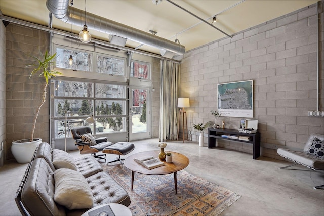 living room with concrete flooring and concrete block wall