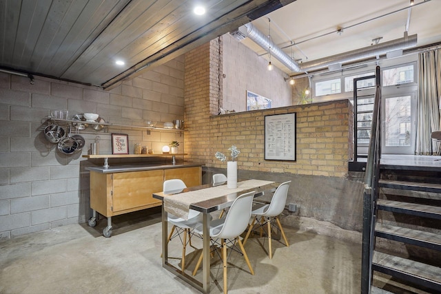 dining space featuring concrete block wall and concrete floors