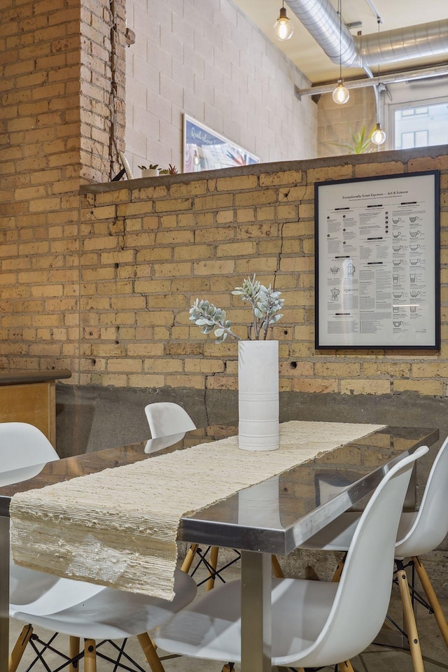 dining space featuring brick wall