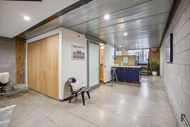 interior space featuring concrete block wall, a sink, and recessed lighting