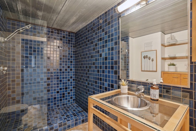 full bathroom with a stall shower, backsplash, tile walls, and vanity