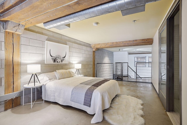 bedroom with concrete block wall and concrete flooring