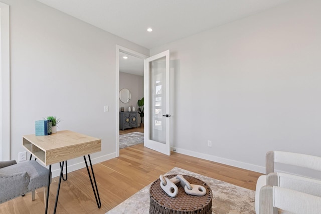 sitting room featuring light wood finished floors, baseboards, and recessed lighting