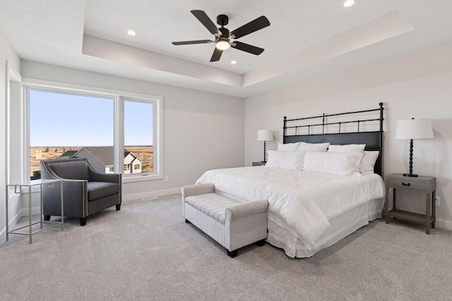 bedroom with a tray ceiling, carpet, baseboards, and recessed lighting