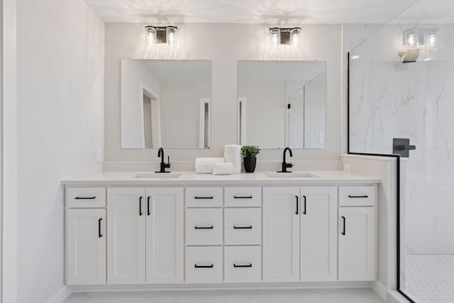 full bath featuring a sink, a marble finish shower, and double vanity