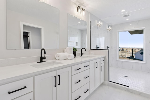 bathroom with marble finish floor, double vanity, a sink, and a marble finish shower