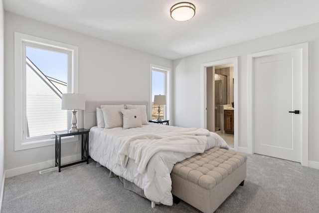 carpeted bedroom with baseboards and connected bathroom