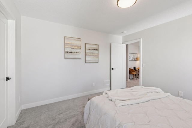 bedroom featuring a textured ceiling, carpet, and baseboards