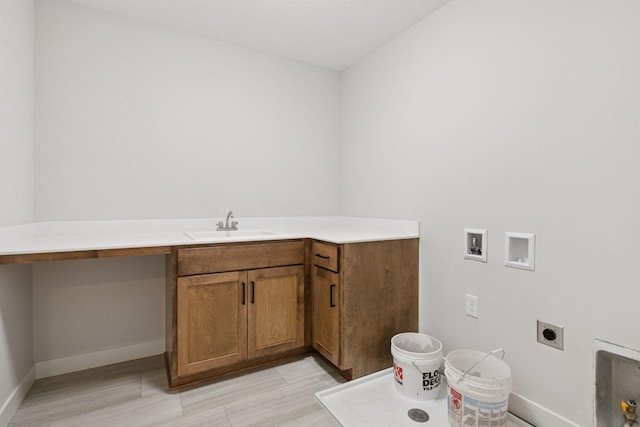 clothes washing area with hookup for a washing machine, a sink, baseboards, cabinet space, and electric dryer hookup