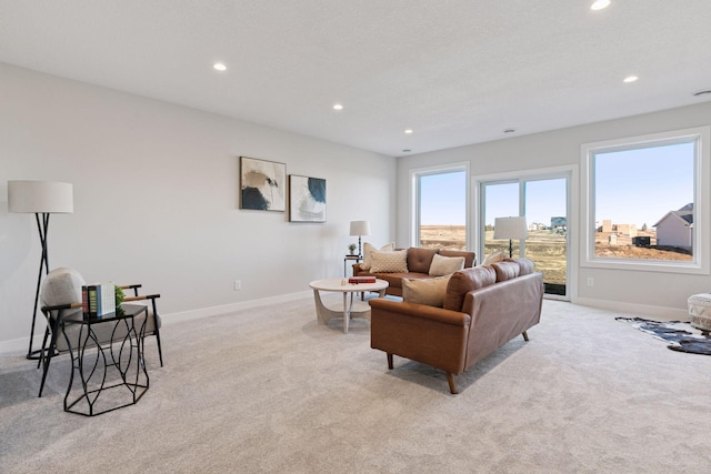 living area with light carpet, recessed lighting, and baseboards