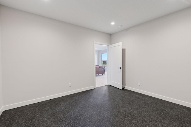 spare room with recessed lighting and baseboards