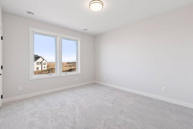 spare room with carpet and baseboards