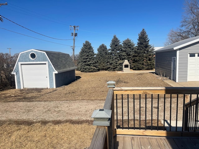 view of yard with an outbuilding, a wooden deck, and a storage unit